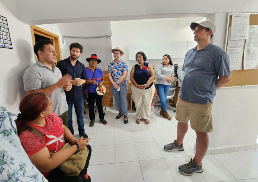 Several people indoors engaged in discussions during the Interledger workshop.