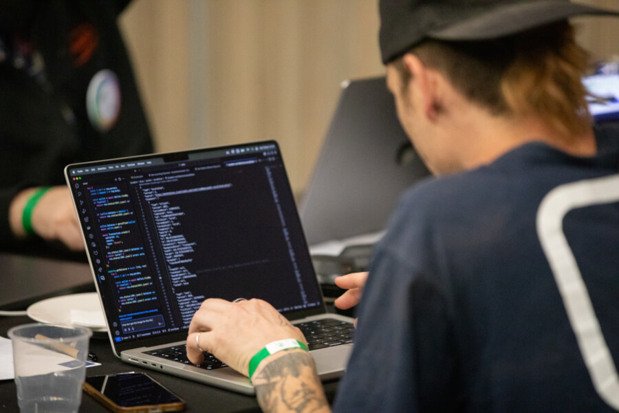 Man coding on a laptop with the screen visible