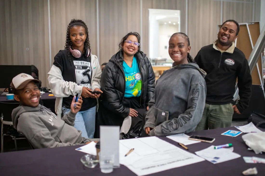 Five members of a hackathon team stand together smiling