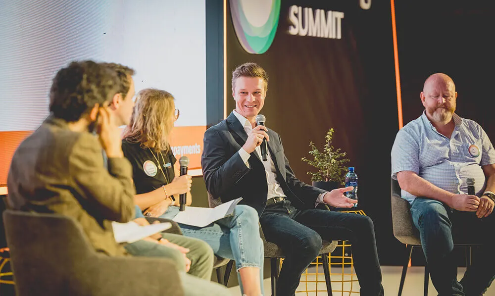 A panel of summit speakers in discussion on stage