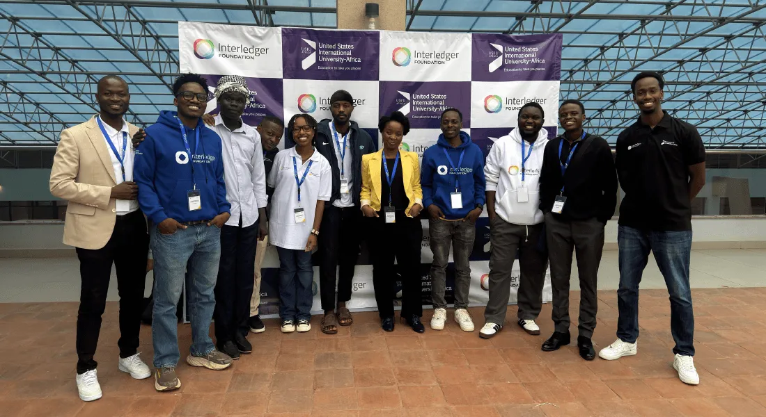 Participants at USIU-Africa pose in front of a banner featuring Interledger Foundation and USIU-Africa logos.