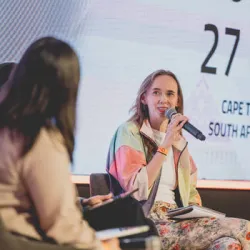 Lady speaking into microphone while on stage